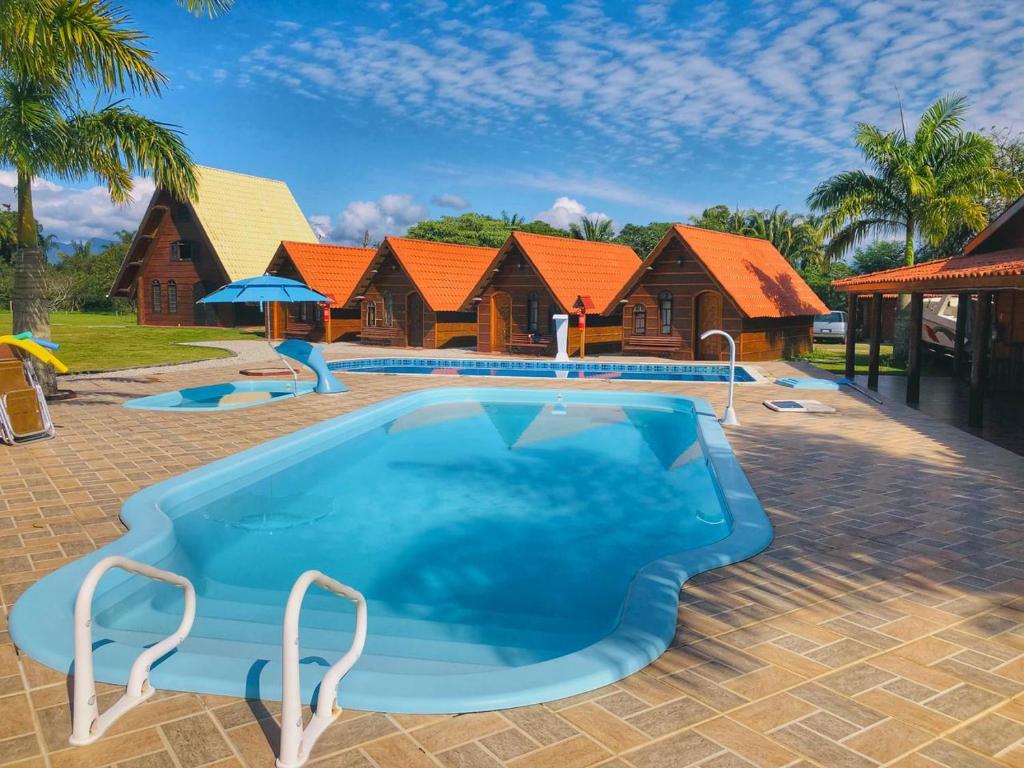 Piscina e chalés do Chalé Caiçara, no Litoral Norte de SP.