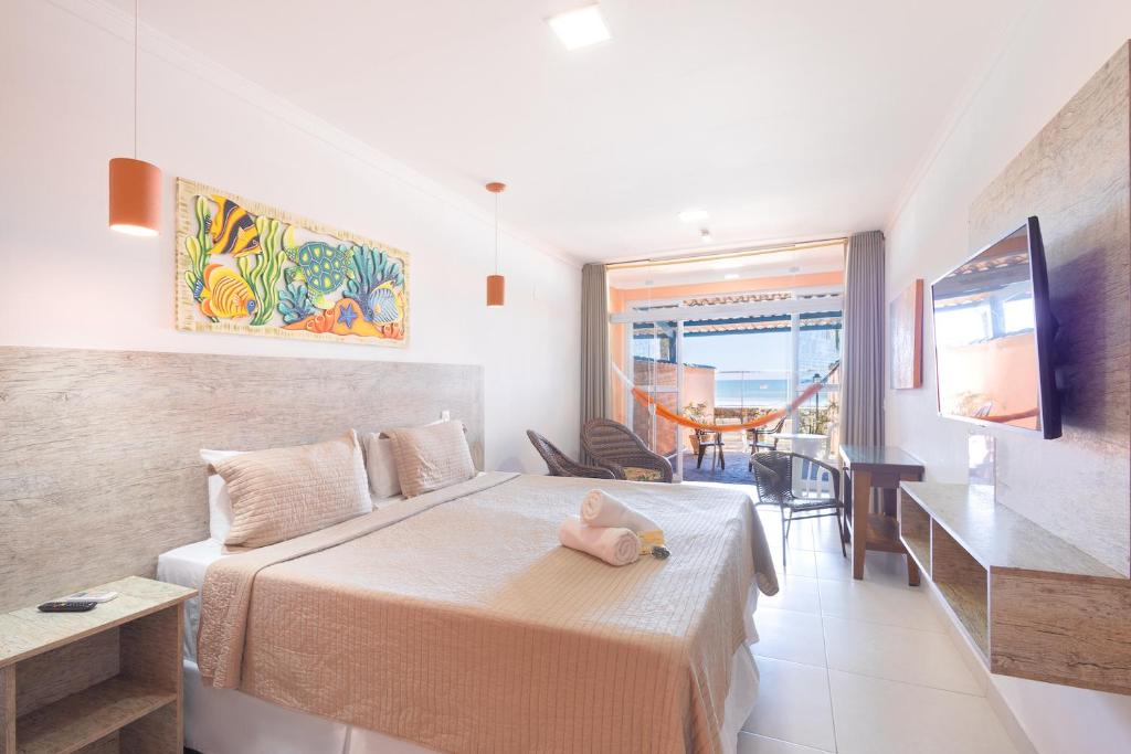 Quarto da Kaliman Pousada, com cama clara, varanda e rede laranja