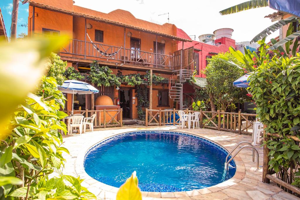 Área externa da Pousada Recanto da Villa, com piscina redonda e fachada colorida