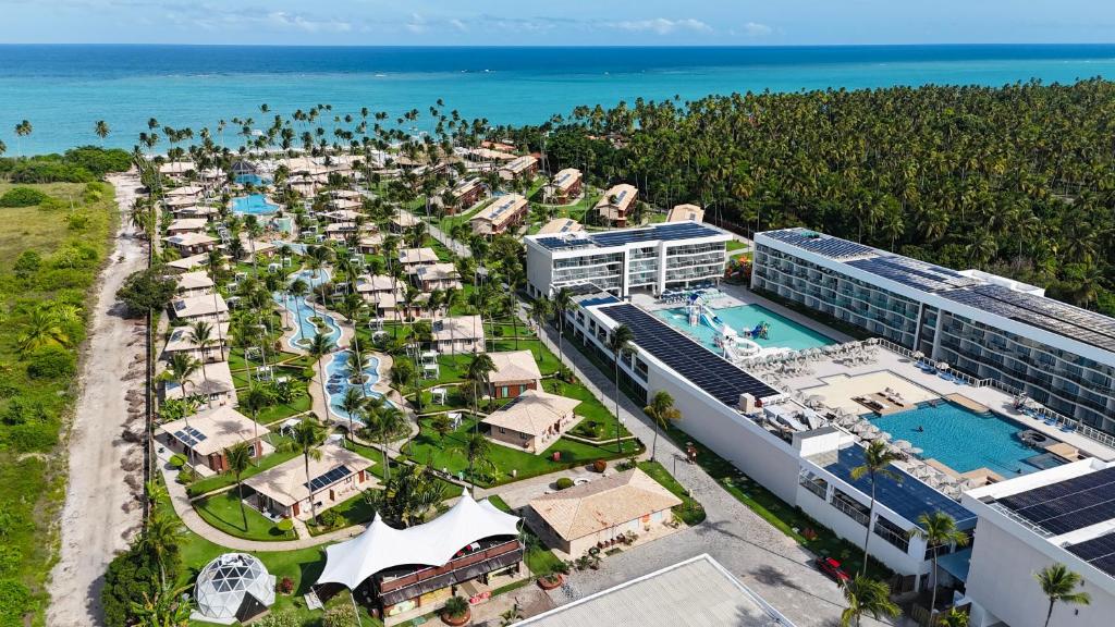 Área do Grand Oca Maragogi All Inclusive Resort, em Maragogi, vista do alto com piscinas, bangalôs e mar ao fundo