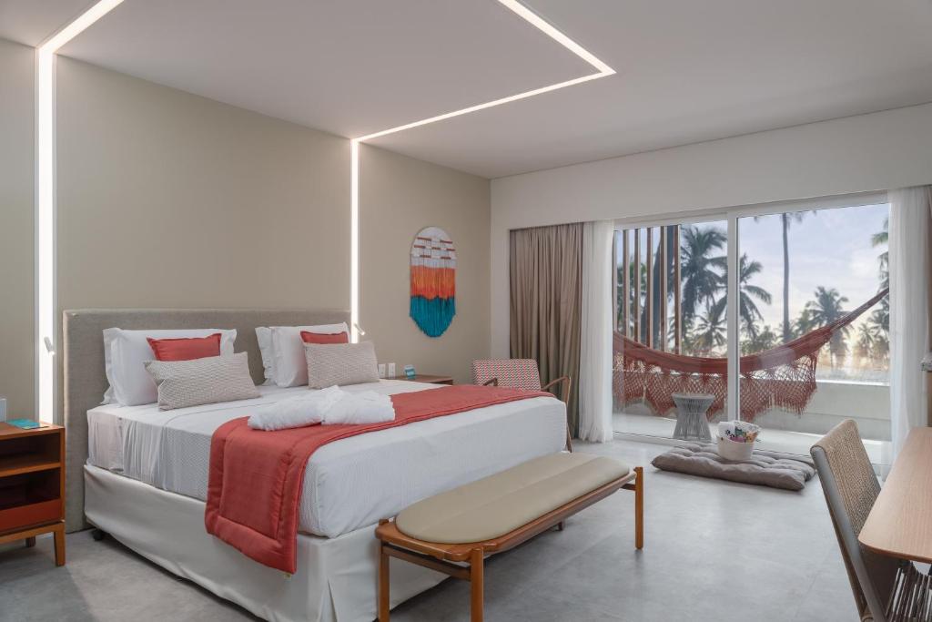 Quarto do Japaratinga Lounge Resort All Inclusive, em Japaratinga, com varanda, rede e vista para coqueiros