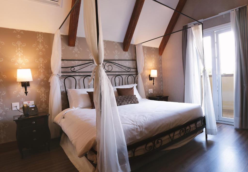 Quarto do Buona Vitta Gramado Resort & Spa by Gramado Parks, em Gramado, com cama de dossel e vigas aparentes