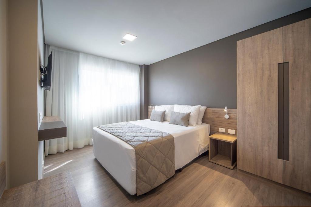 Quarto do Laghetto Resort Golden Oficial, em Gramado, com cama de casal e móveis em madeira clara