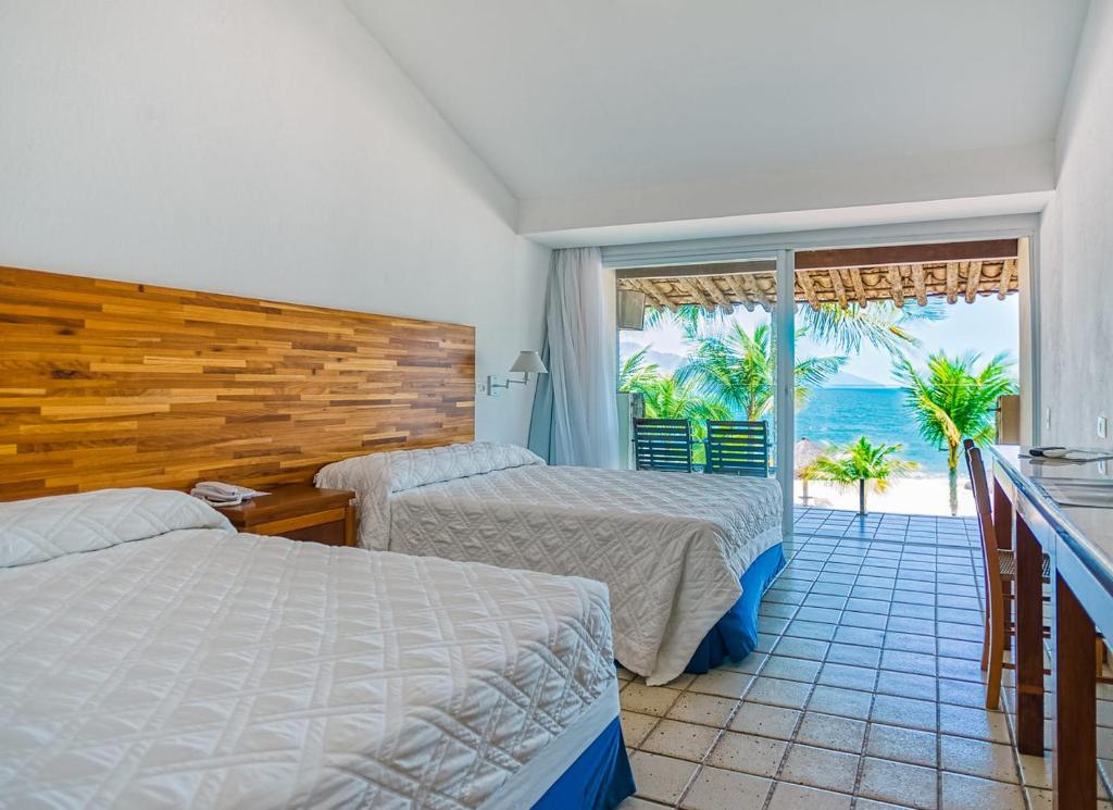 Quarto do Hotel Portobello Resort & Safari, em Mangaratiba, com duas camas e varanda voltada para o mar.