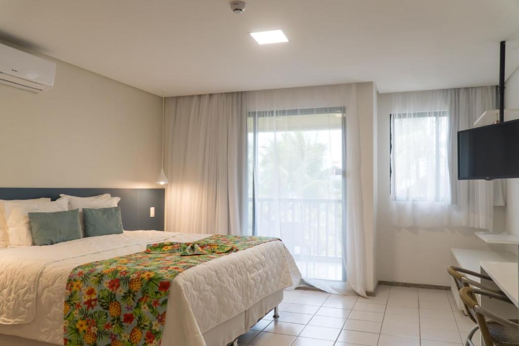 Quarto do Marulhos Resort by MAI, em Porto de Galinhas, com cama branca e varanda