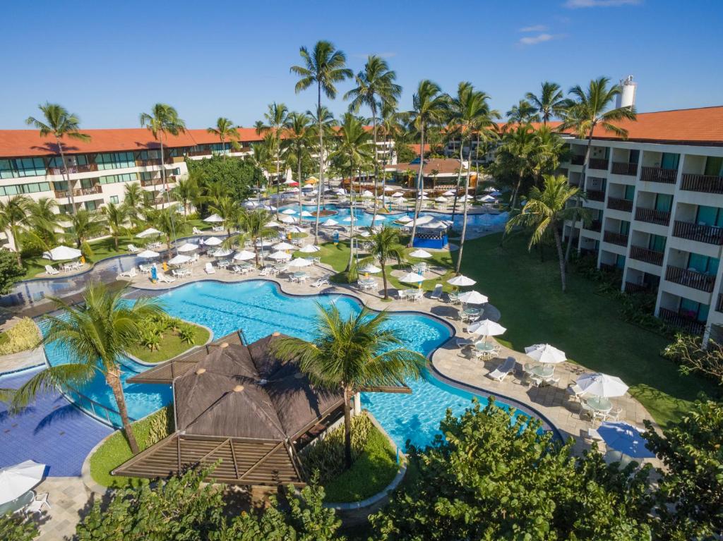 Área de piscinas do Marulhos Resort by MAI, em Porto de Galinhas, com coqueiros e prédios ao redor