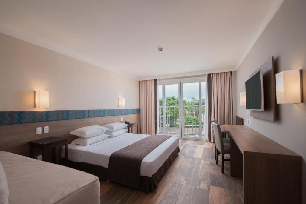 Quarto do Marupiara All Inclusive Resort by Wish, em Porto de Galinhas, com cama e varanda