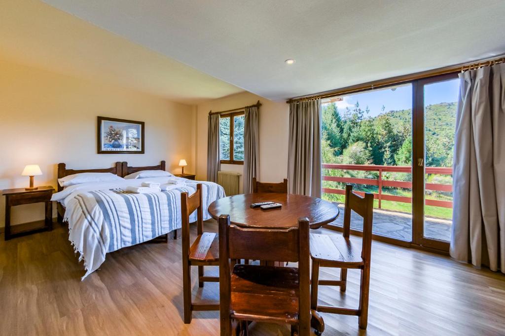 Quarto do Le Chateau, em Bariloche, com cama de casal e varanda voltada para o lago.