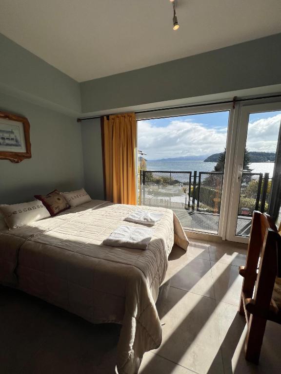 Quarto do Apartur Catedral, em Bariloche, com duas camas e varanda voltada para a vegetação.