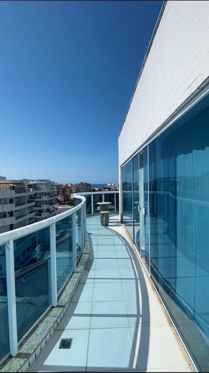 Varanda do Hotel Real, em Cabo Frio, com guarda-corpo de vidro e vista parcial para o mar