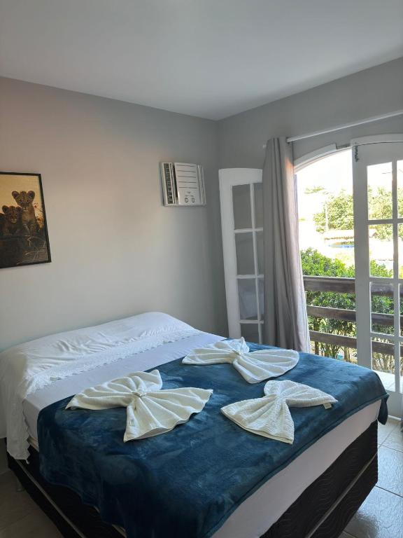 Quarto da Pousada e Hostel Aruana, em Cabo Frio, com cama de casal e varanda
