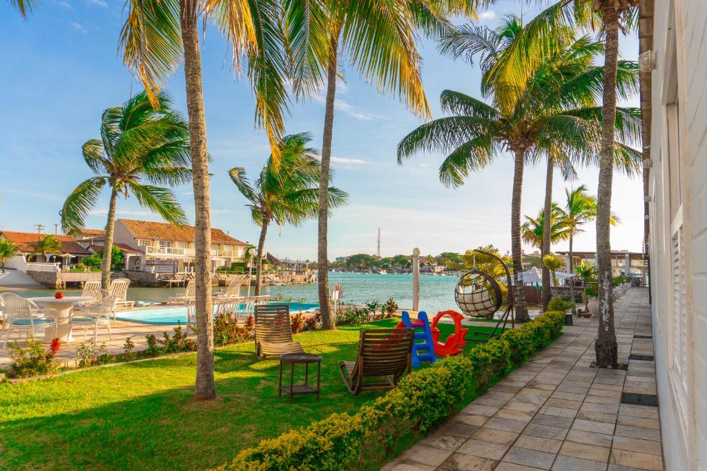 Área externa da Pousada Marília, em Cabo Frio, com jardim, piscina e vista para o canal