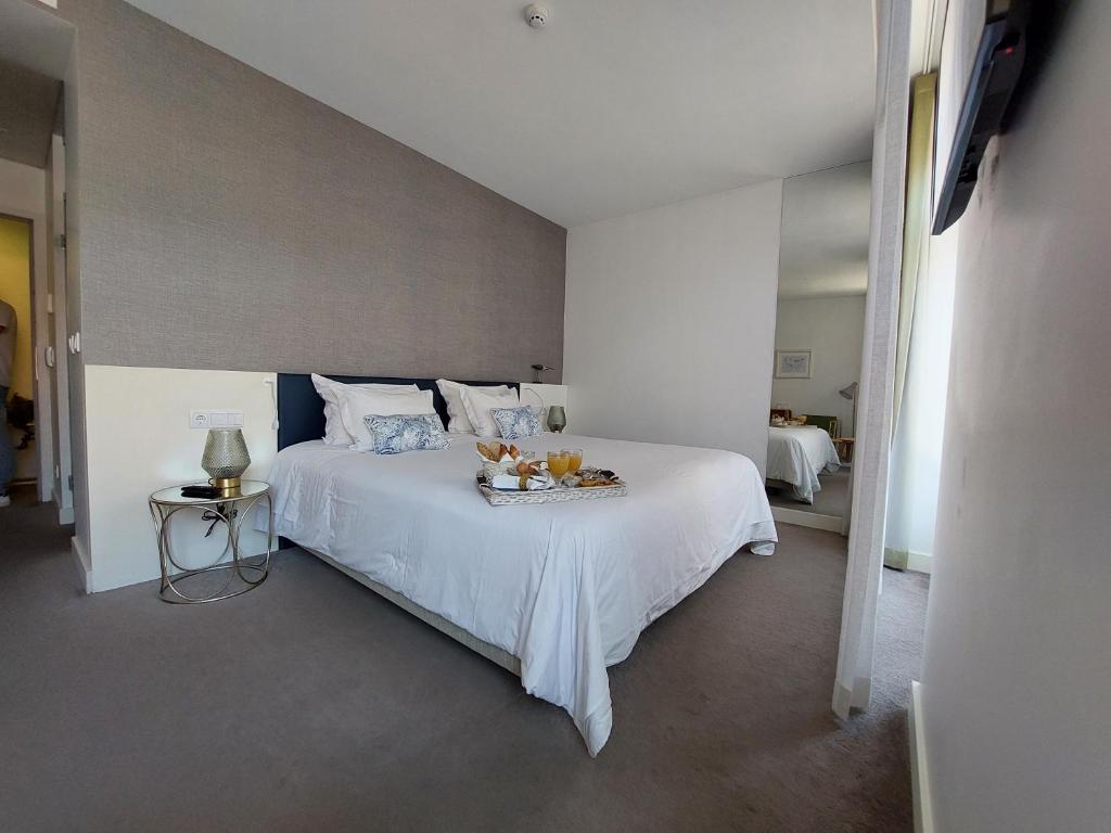 Quarto da Augusta Boutique House, em Lisboa, com cama de casal e café da manhã servido sobre o enxoval.