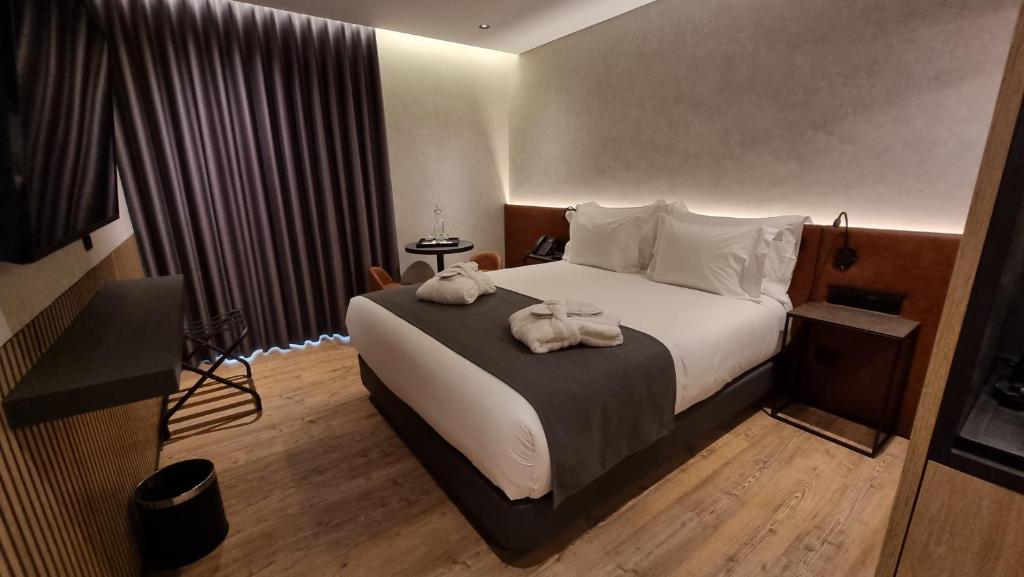 Quarto do Hotel Principe Avila, em Lisboa, com cama de casal, decoração contemporânea e piso de madeira.