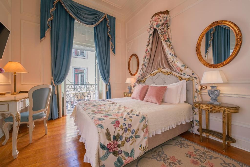 Quarto do Palácio das Especiarias, em Lisboa, com cama de dossel, tecidos florais e cortinas azuis.