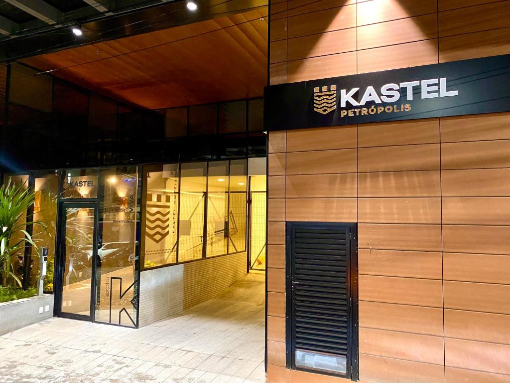 Fachada do Kastel Petrópolis, em Petrópolis, com entrada moderna iluminada à noite.