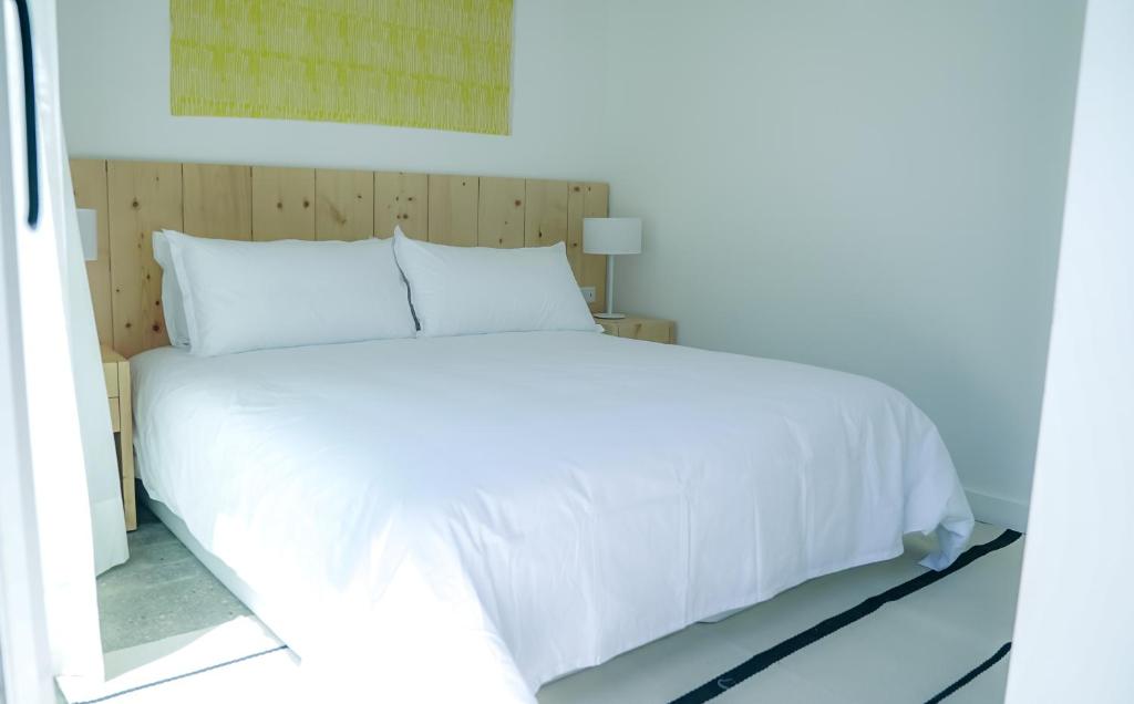 Quarto do Casagrande Hotel & Beach Club, em Punta del Este, com cama de casal, cabeceira de madeira e decoração clara.