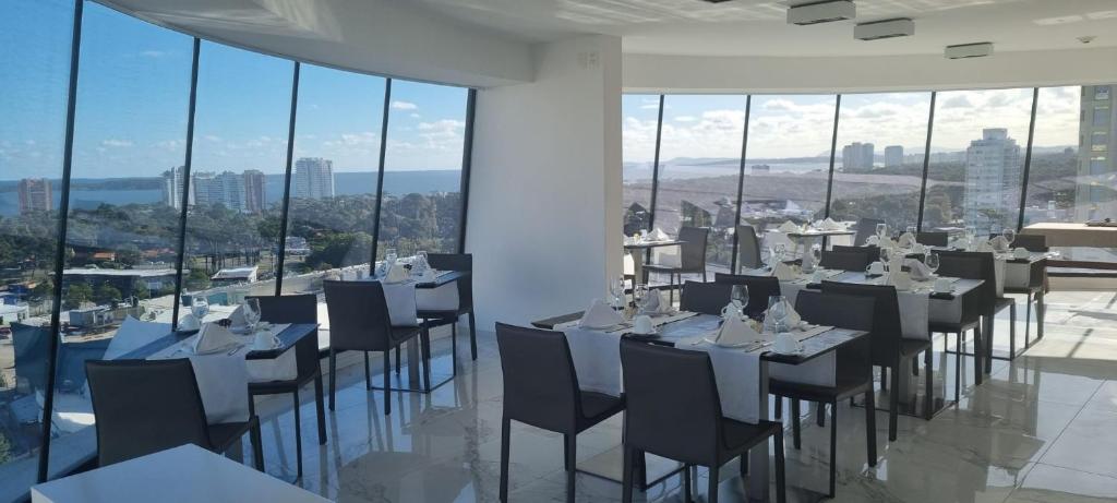 Restaurante do Don Hotel, em Punta del Este, com mesas junto às grandes janelas e vista panorâmica da cidade.