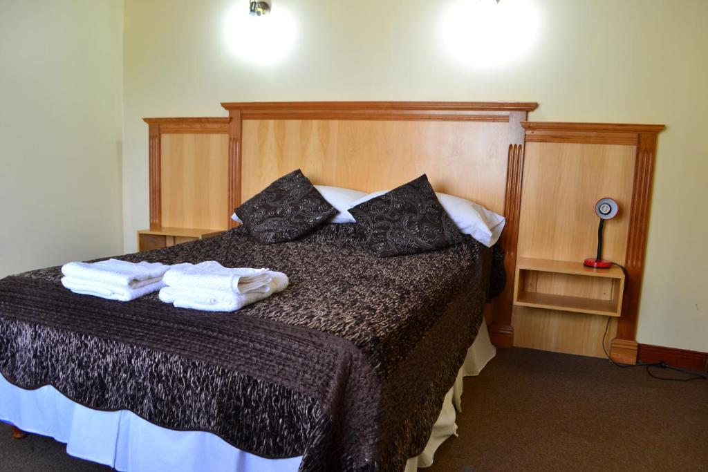 Quarto do Valle Frío Ushuaia, em Ushuaia, com cama de casal e móveis de madeira.