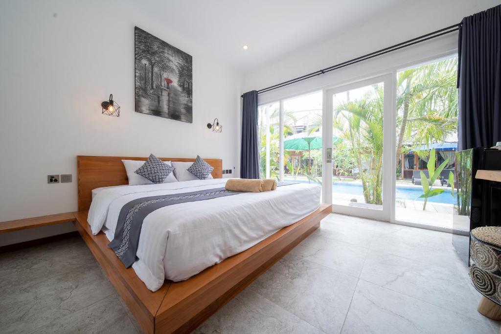 Quarto do Easy Surf Camp, em Bali, com cama de casal e porta de vidro voltada para a piscina