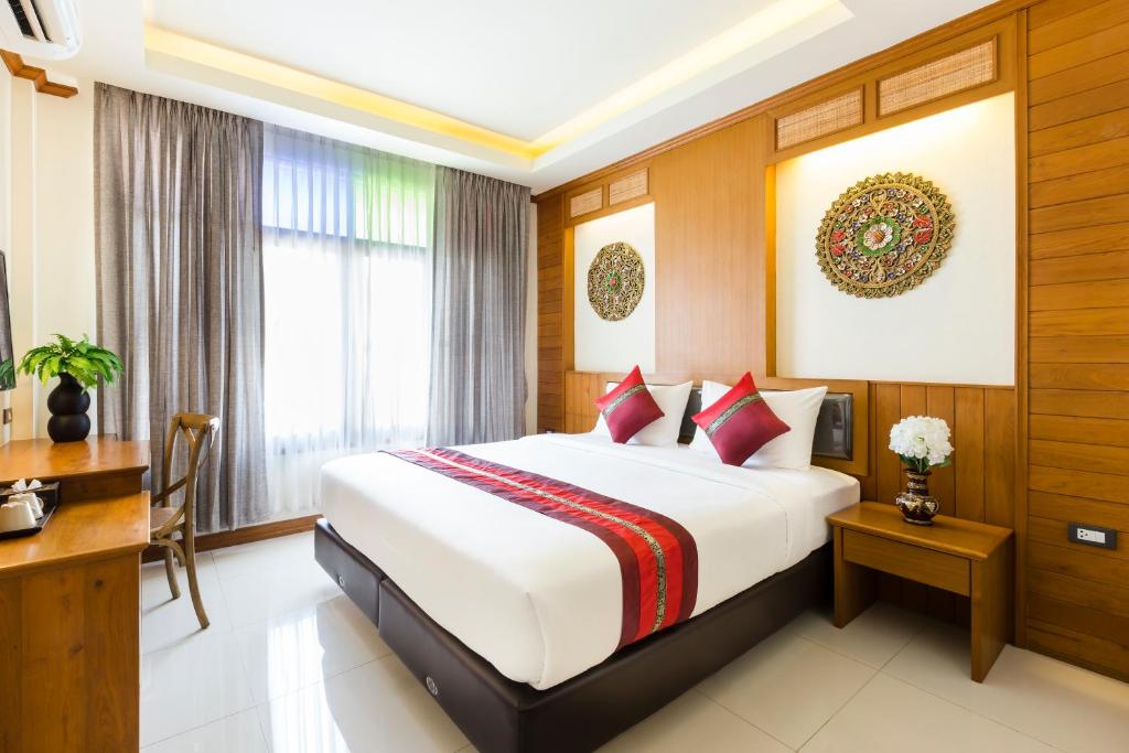 Quarto com painel de madeira esculpido e detalhes vermelhos em Chiang Mai.