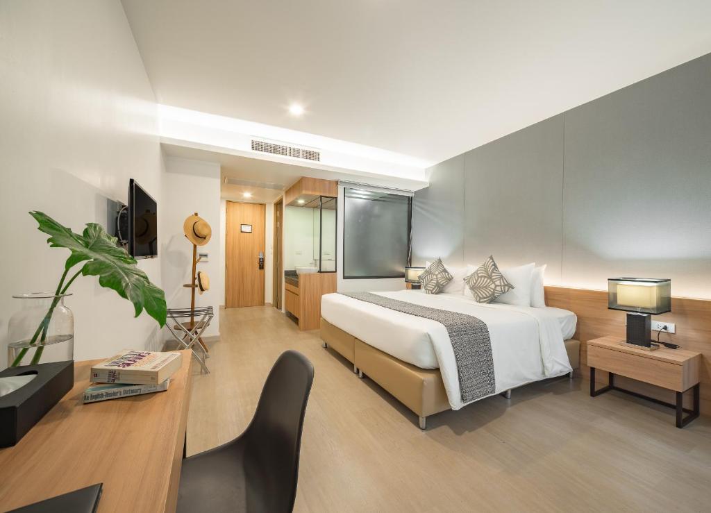 Quarto espaçoso com piso de madeira e tons neutros em Chiang Mai.