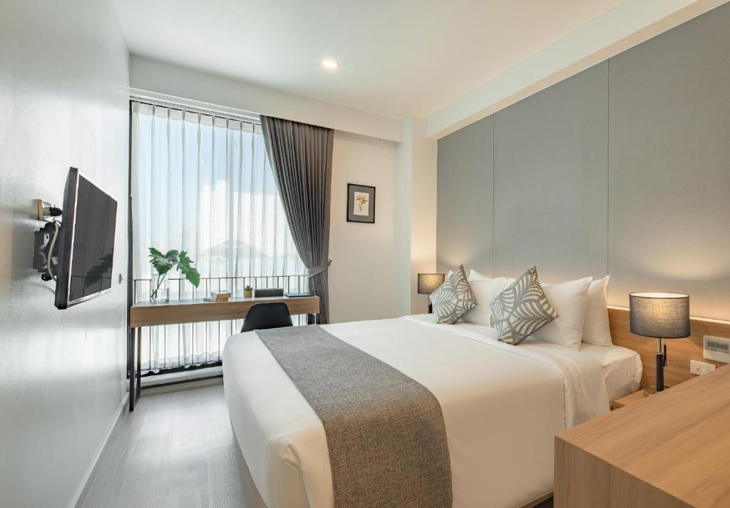 Quarto iluminado com janela ampla e bancada de trabalho em Chiang Mai.