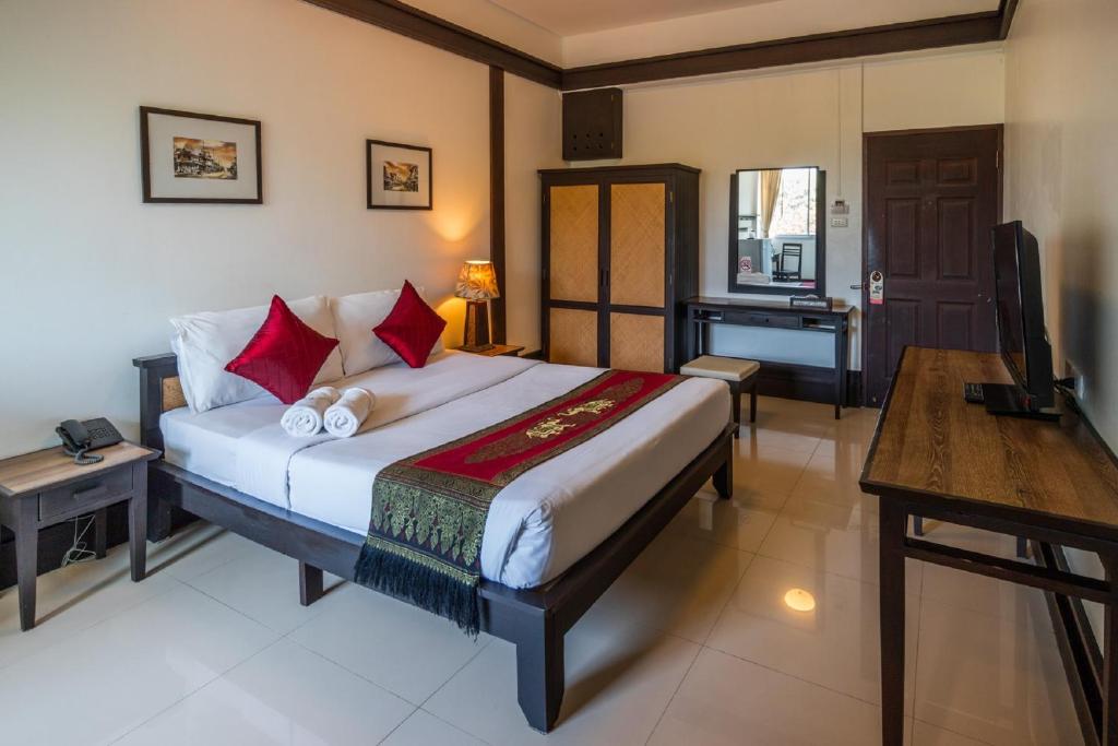 Quarto aconchegante com cama de casal e detalhes em madeira em Chiang Mai.