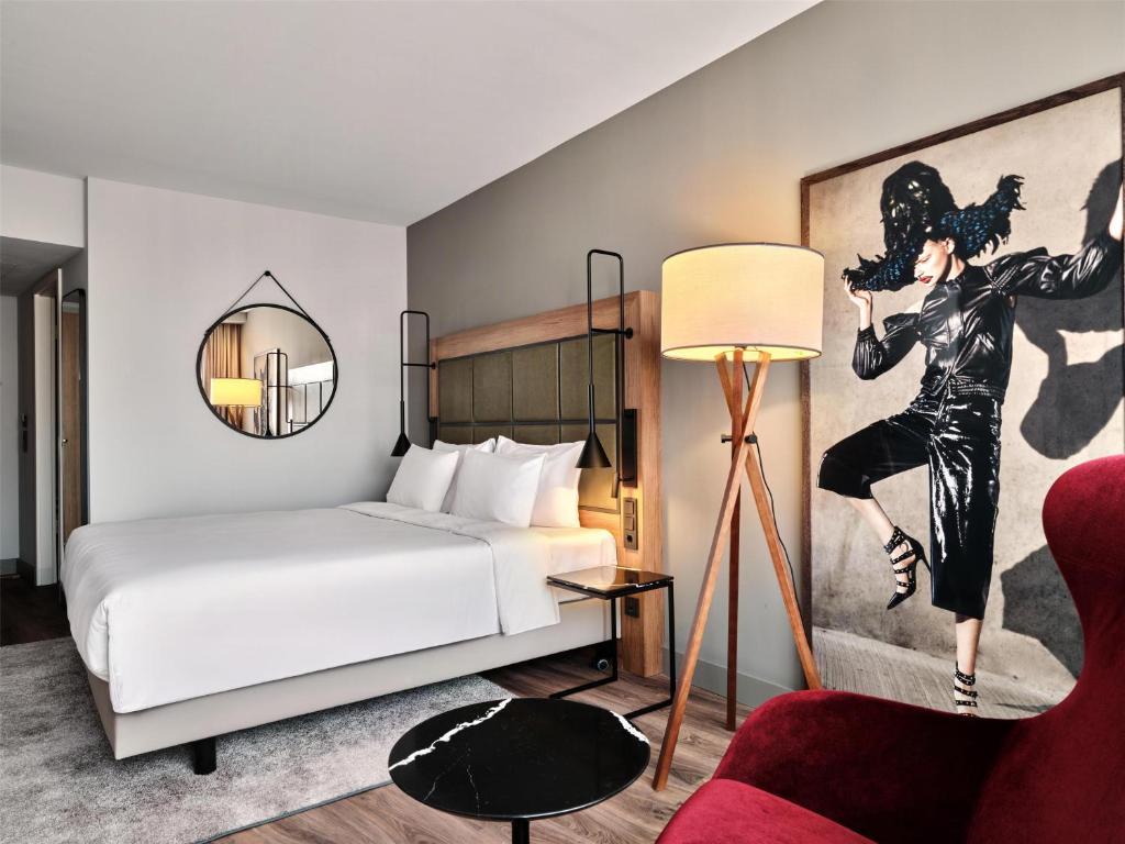 Quarto elegante com cama de casal, espelho redondo suspenso e quadro decorativo de arte moderna em Hamburgo.