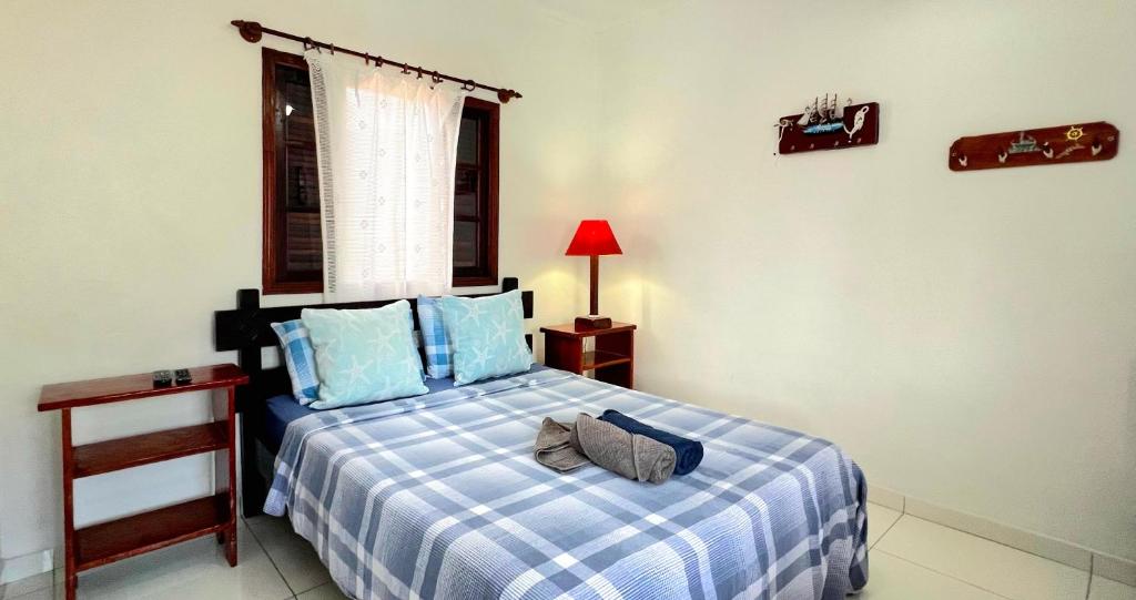 Quarto da Pousada Suítes Nova Mar Ilhabela, com cama de casal e decoração em azul.