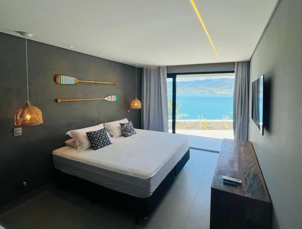 Quarto das Suítes na Casa da Praia, em Ilhabela, com cama de casal e vista direta para o mar.