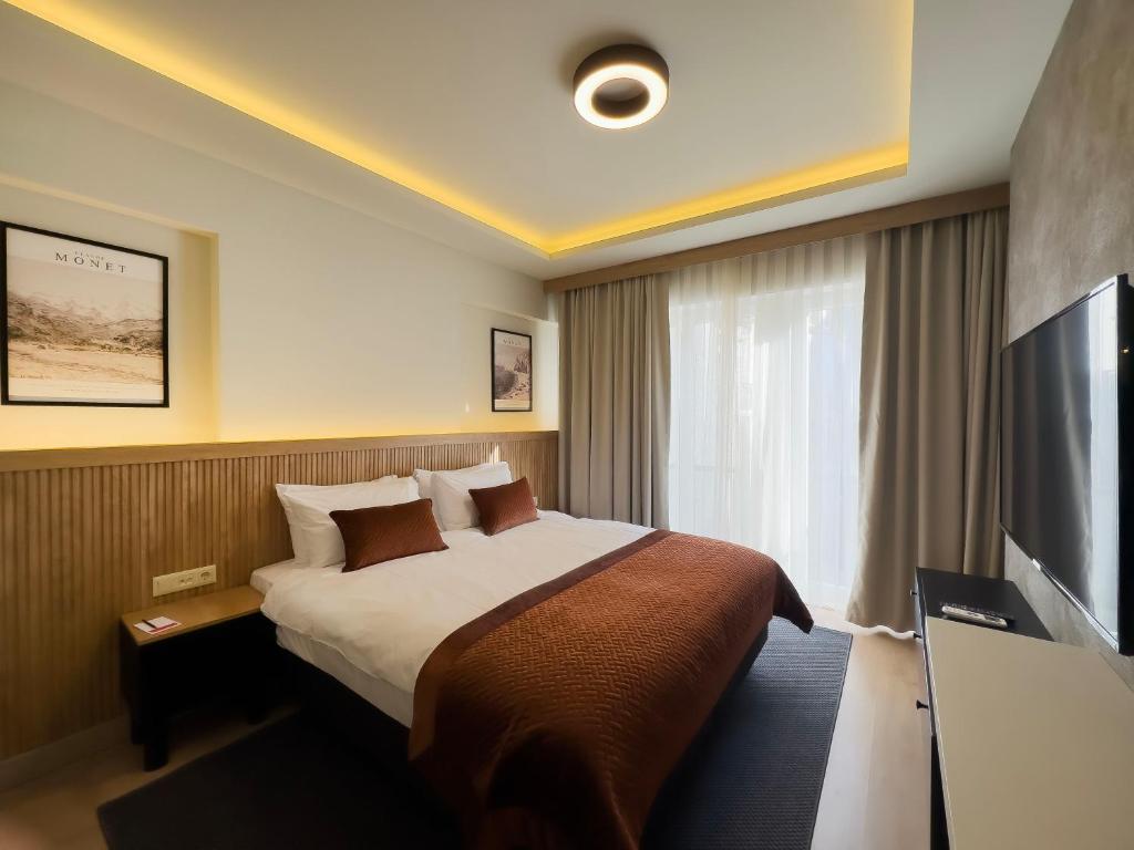 Quarto do Dugi, em Istambul, com cama de casal, detalhes em terracota e iluminação indireta.