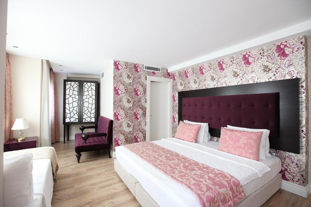 Acomodação do Katelya Hotel, em Istambul, com cama de casal, papel de parede floral e detalhes em rosa.
