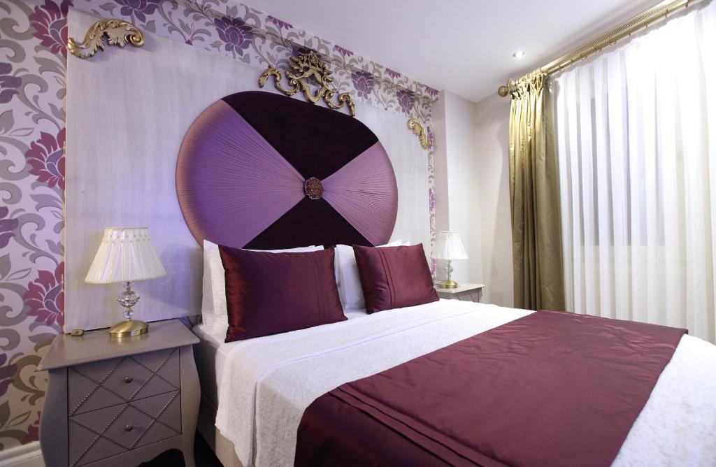 Quarto do Katelya Hotel, em Istambul, com cama de casal e decoração em tons de roxo e dourado.