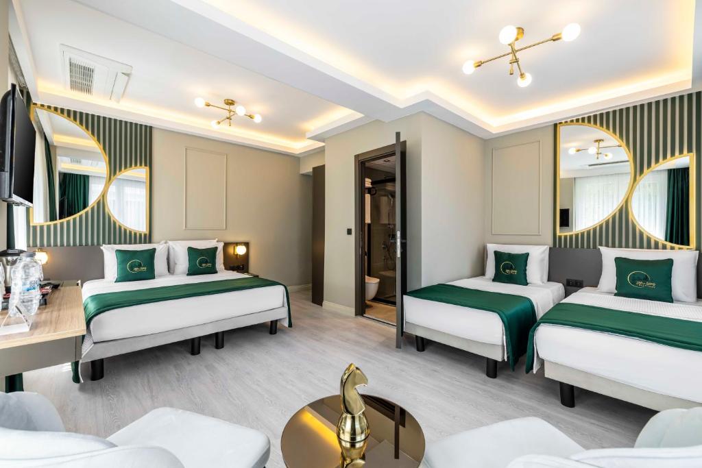 Quarto do Sistina Old City Hotel, em Istambul, com três camas e decoração verde e dourada.