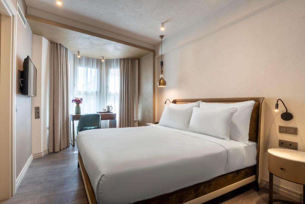 Acomodação do Smart and Simple Hotel Karakoy, em Istambul, com cama de casal e escrivaninha junto à janela.