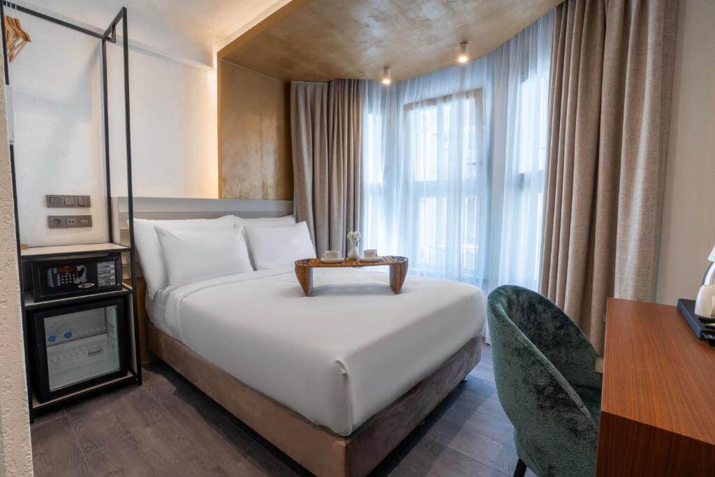 Quarto do Smart and Simple Hotel Karakoy, em Istambul, com cama de casal e grandes janelas.
