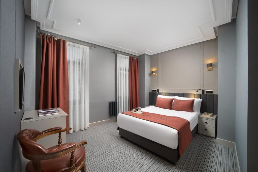 Acomodação do Union Plat Inn Special Category, em Istambul, com cama de casal, poltrona de couro e janelas altas.