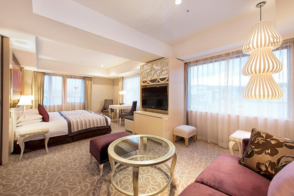 Quarto do Hotel Grand Bach Kyoto Select, em Kyoto, com cama de casal, sala integrada e luminárias decorativas.