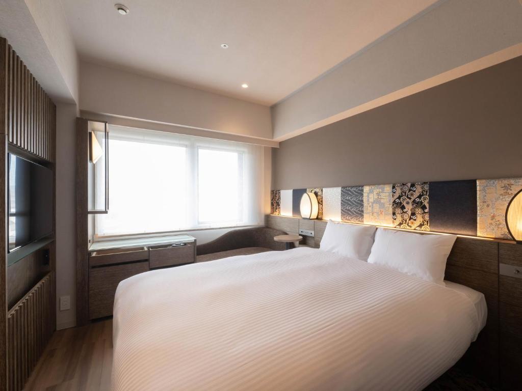 Quarto do insomnia KYOTO OIKE, em Kyoto, com cama de casal, decoração em madeira e detalhes estampados na cabeceira.