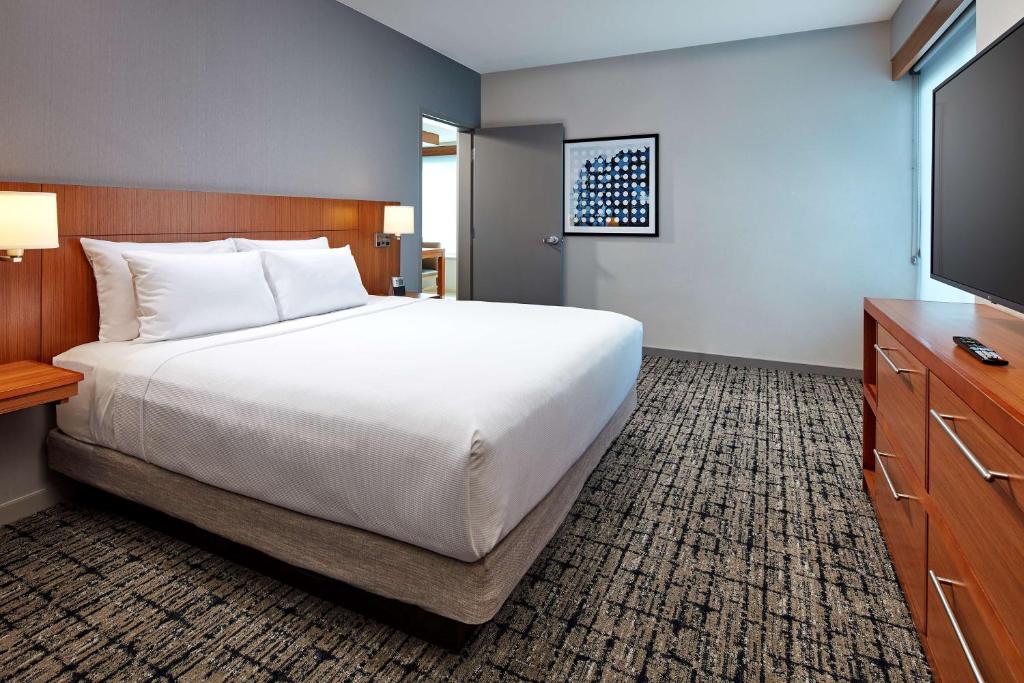 Quarto do Hyatt Place Los Angeles LAX El Segundo com cama de casal, móveis de madeira e TV na parede