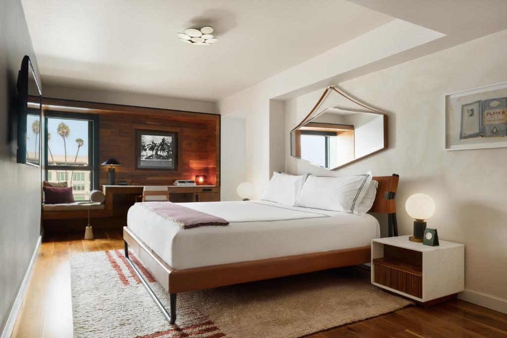 Quarto do SIXTY Beverly Hills com cama de casal, parede de madeira e espelho acima da cabeceira