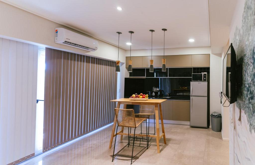 Cozinha integrada com bancada e mesa de madeira no Le Montreal Apartments em Mendoza, com persianas e iluminação moderna.