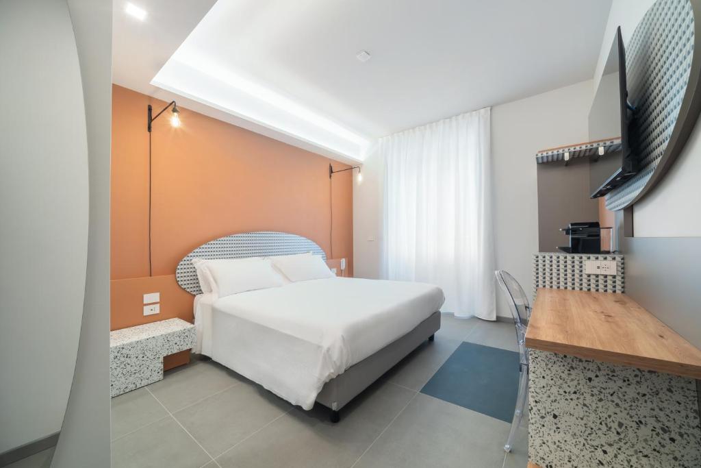 Quarto da Brera Guest House, em Milão, com cama de casal, parede terracota e bancada de trabalho