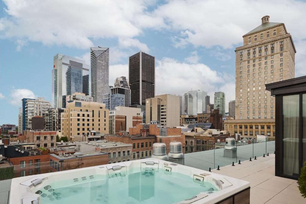 Terraço do Eurostars Old Montreal Suites and Apartments, em Montreal, com hidromassagem e vista para os prédios da cidade.