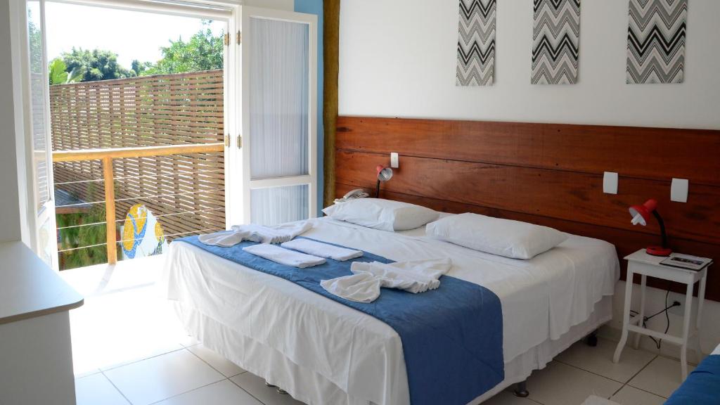 Quarto da Pousada Cana Caiana, em Paraty, com cama de casal, varanda e detalhes em azul.