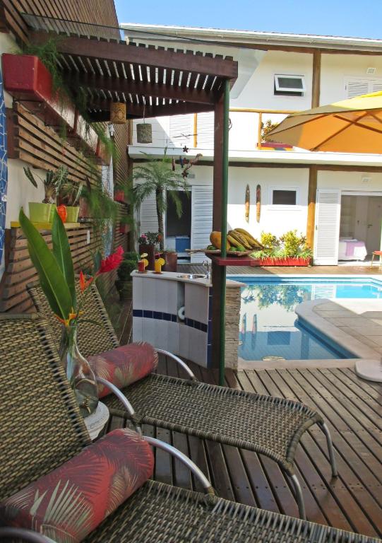 Área externa da Pousada Cana Caiana, em Paraty, com espreguiçadeiras, plantas e piscina.