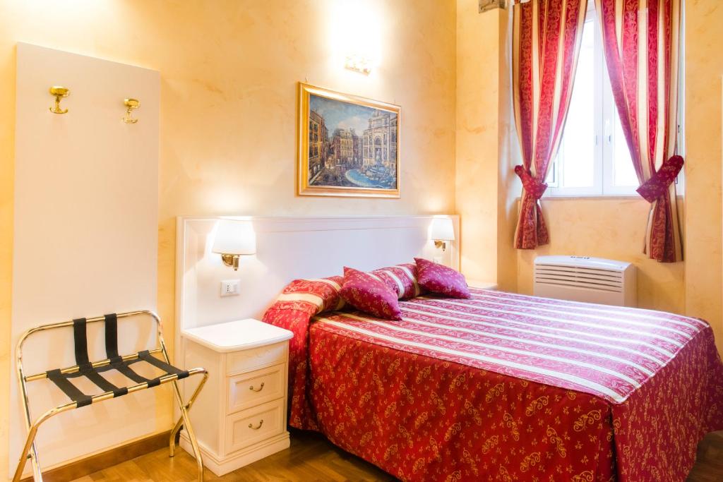 Quarto do Domus Trevi, em Roma, com cama de casal e decoração em tons de vermelho.
