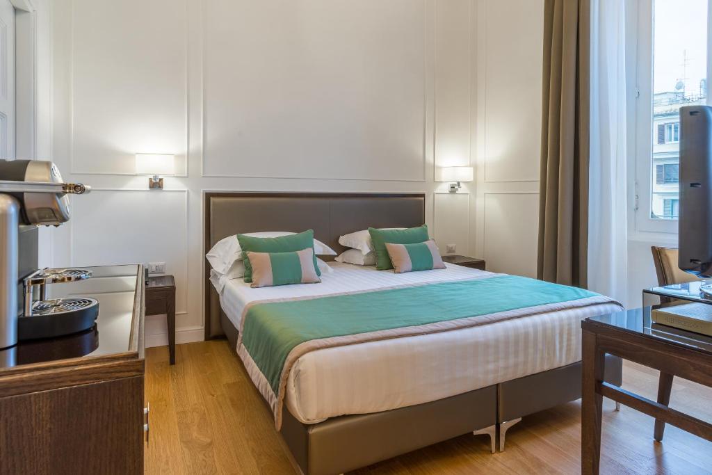 Quarto do Internazionale Domus, em Roma, com cama de casal e detalhes em verde.