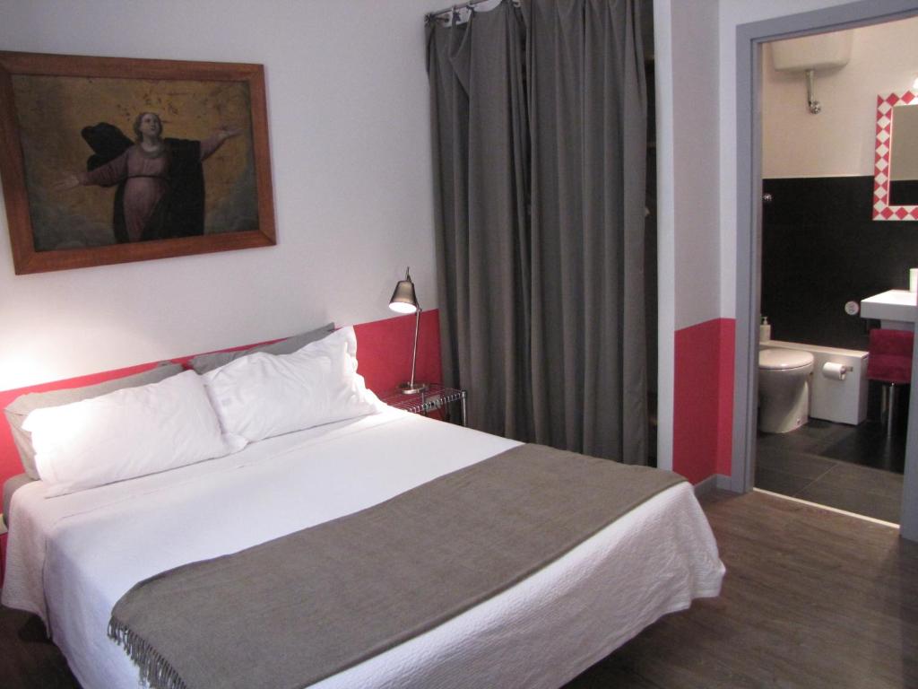 Quarto do Trastevere Colors, em Roma, com cama de casal e detalhes em rosa e cinza.